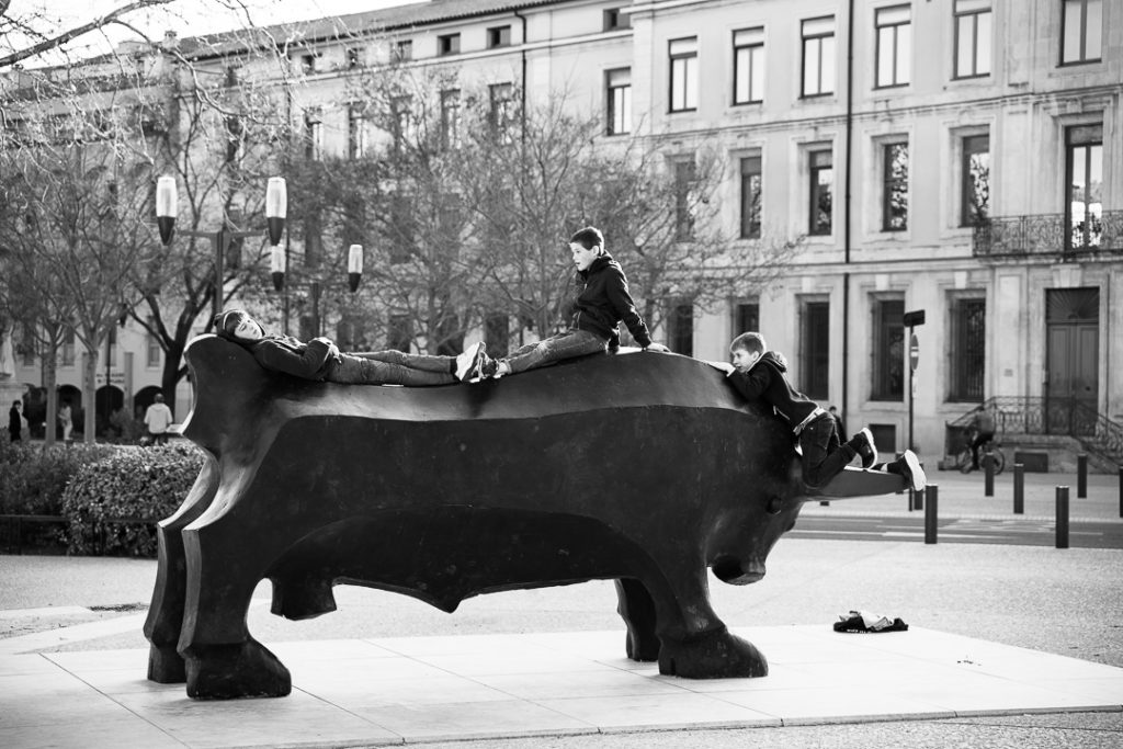 Trois petits caïds s'emparent fièrement et difficilement pour certains, du taureau Nîmois trônant sur l'esplanade. Sculpteur Djoti Bjalava