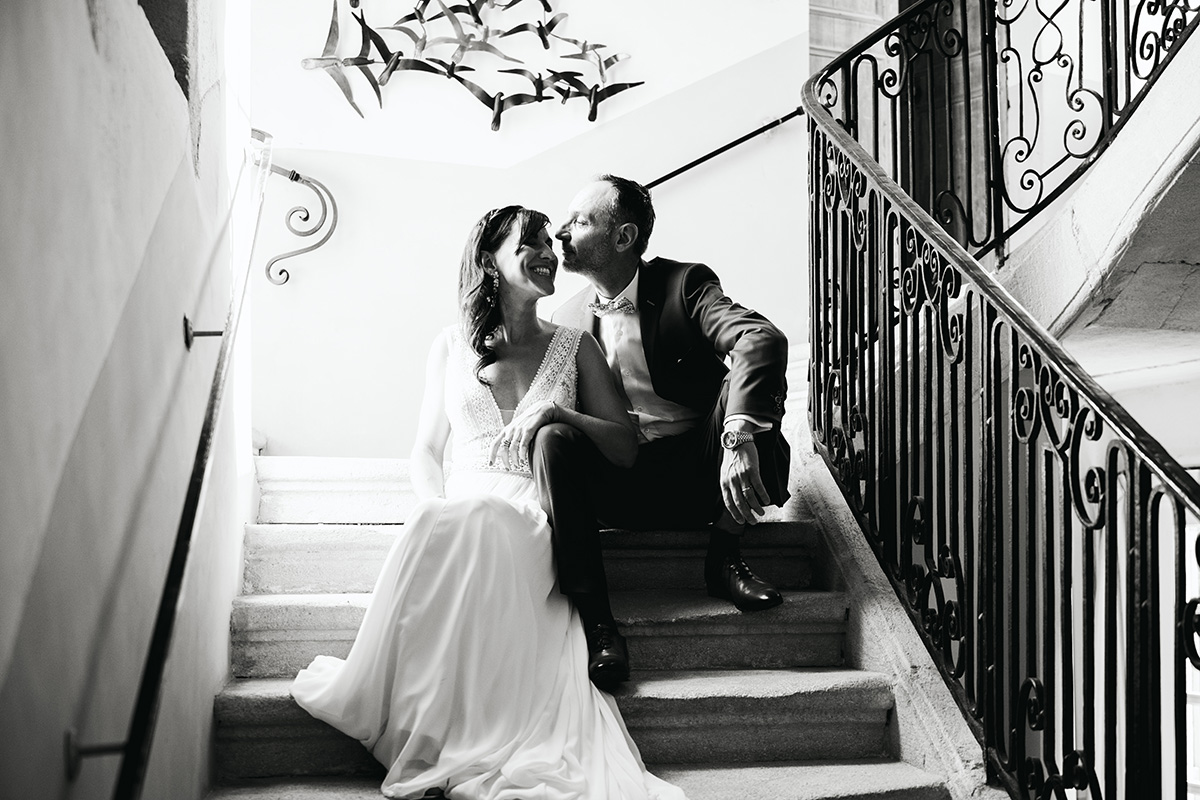 Le couple de mariés assis sur un escalier de leur hôtel.