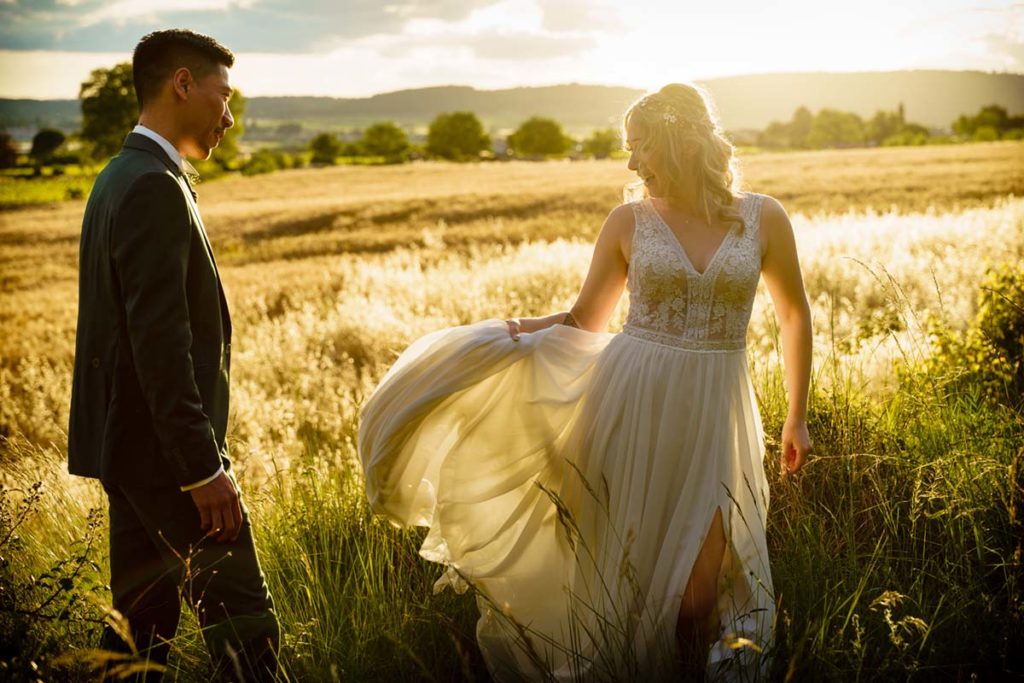 Séance photo de couple au coucher du soleil dans un champ de blé.