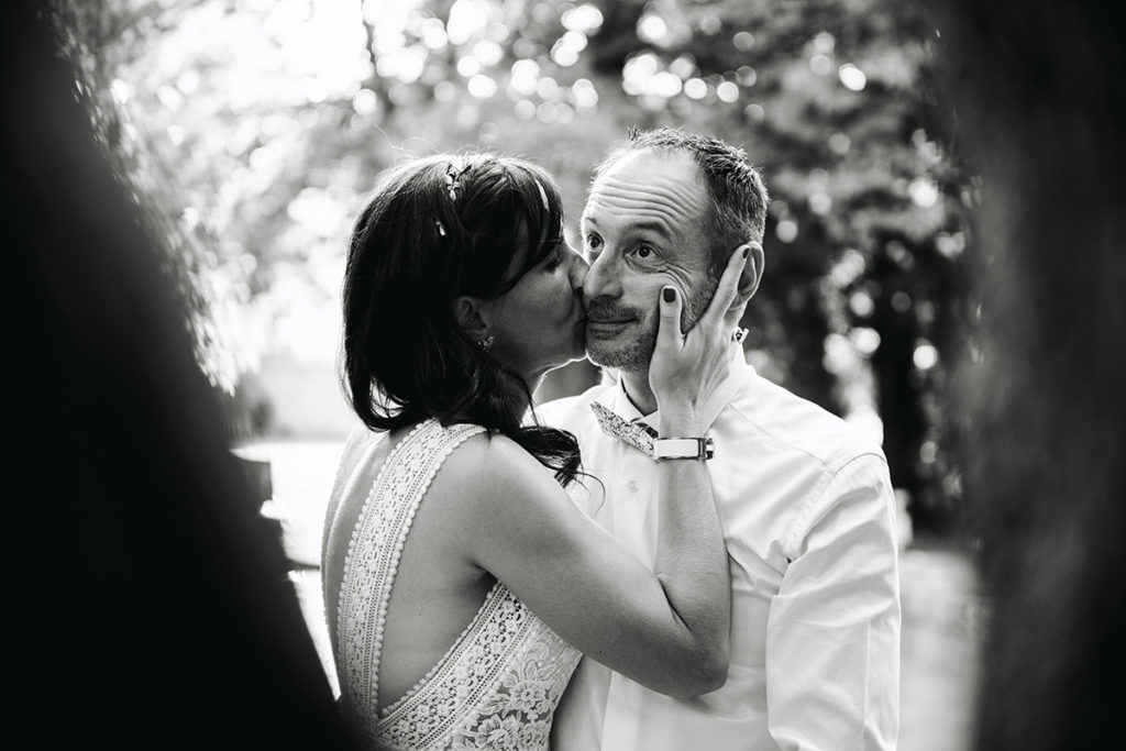 Regard enfantin du marié lorsque la mariée l'embrasse sur la joue.